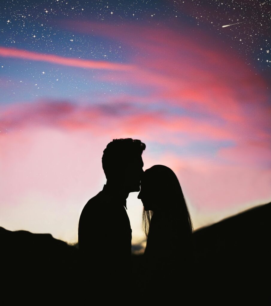 pexels-photo-2494701-2494701 Silhouetted couple sharing an intimate moment against a colorful twilight sky.